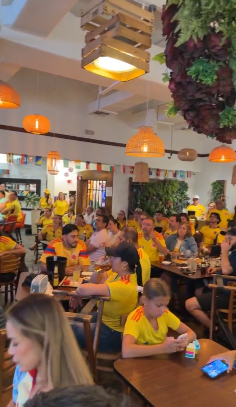 Packed dining room of fans in yellow jerseys watching a Colombia match