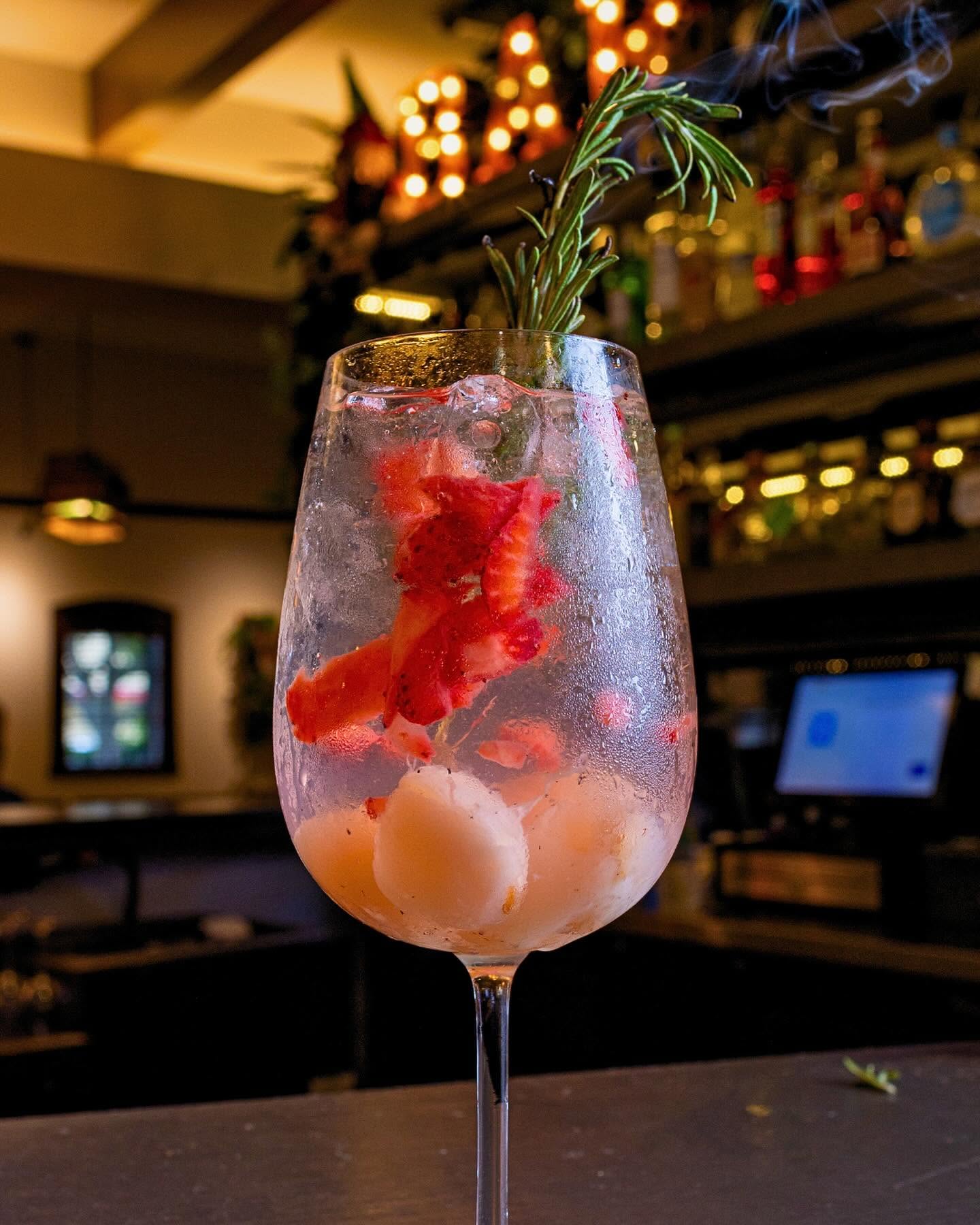 Strawberry and lychee spritz with smoking rosemary at the bar